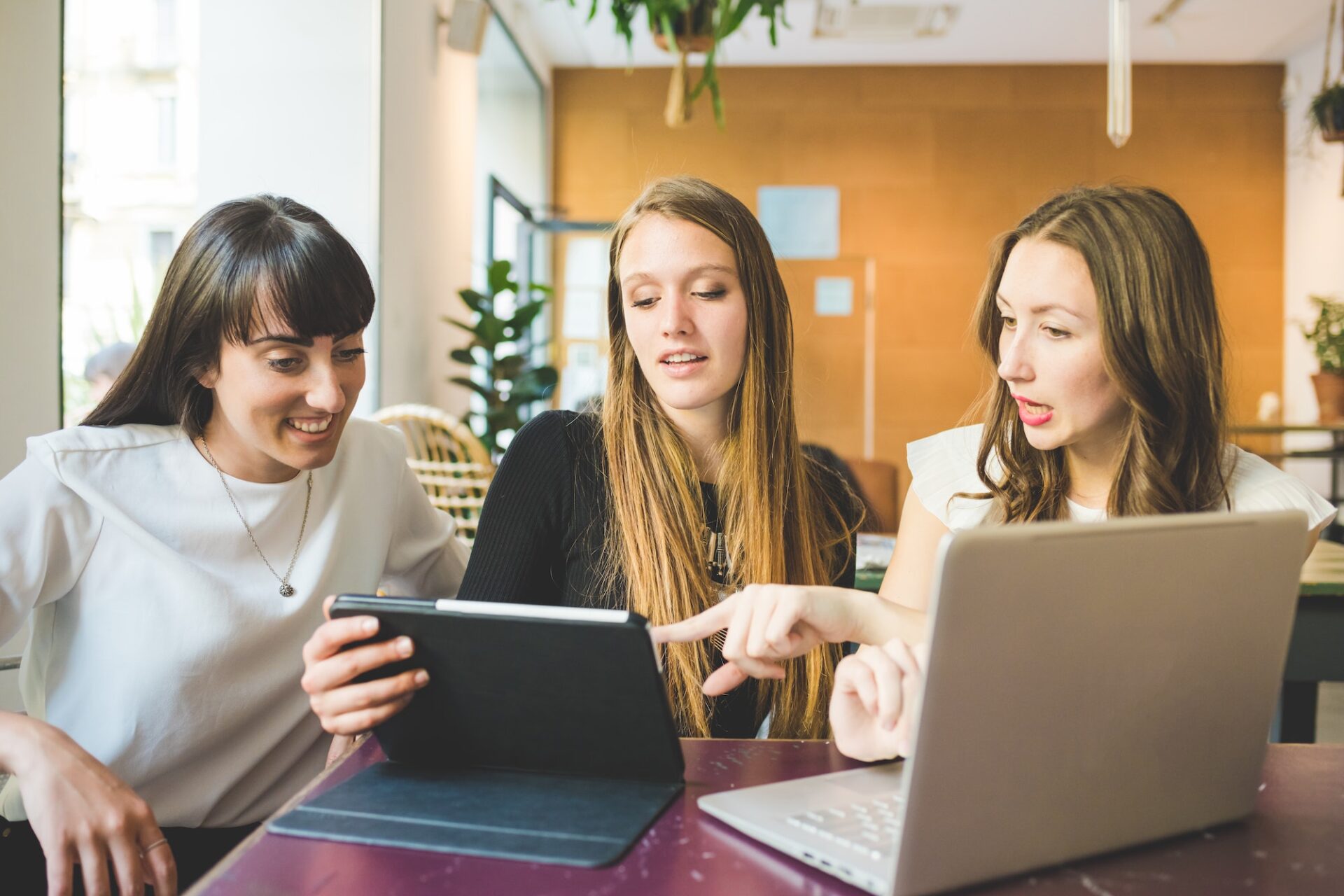 Three women indoor using computer business multitasking